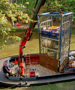 840749 Afbeelding van het lossen van een container met dranken vanaf de Bierboot bij de werf aan de Oudegracht ...